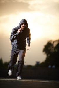 Portrait of young sportsman running in the evening