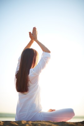 Side view of young woman doing yoga against clear sky outdoors